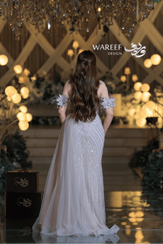 فستان سهرة فضي فاخر بتطريز لامع وأكمام من الريش ال...