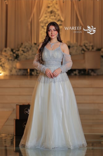 فستان سماوي فاتح مع فتحه بالكتف مزين بالفصوص اللام...