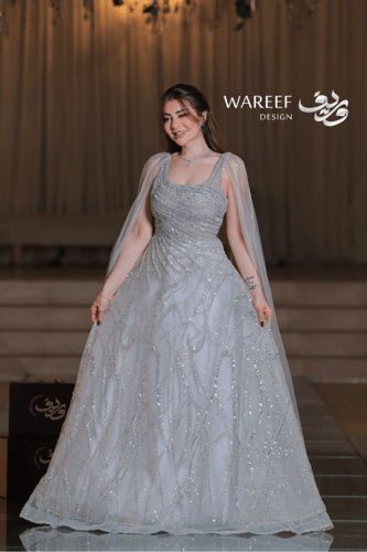 فستان فضي فاخر بتطريز متقاطع ولمعة براقة وأكمام كا...