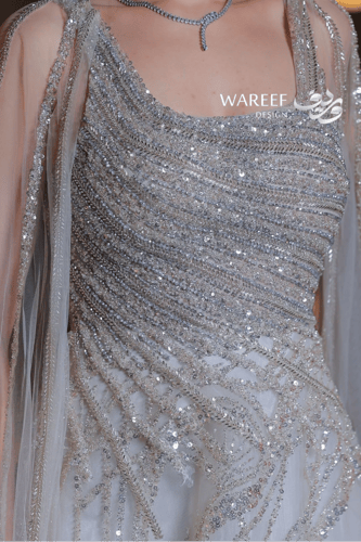 فستان فضي فاخر بتطريز متقاطع ولمعة براقة وأكمام كا...