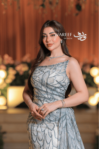 فستان سهرة عاجي فاخر بتطريز زهري لامع وقصّة كتف وا...