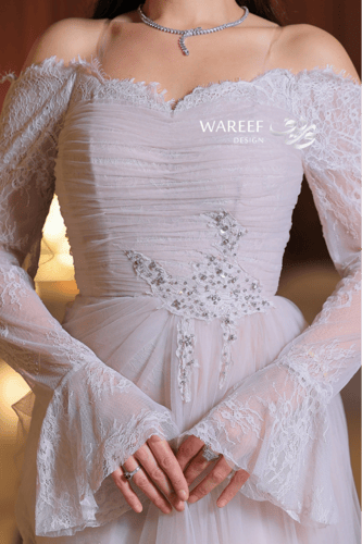 فستان عاجي ناعم بتصميم أكتاف منسدلة ودانتيل راقٍ ب...