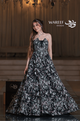 فستان أسود طويل مطرّز بالورود الملونة مع لمسات ترت...