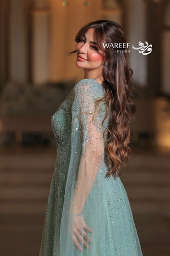 فستان أخضر فاتح طويل مطرز بأكمام شفافة مع ريش فاخر...