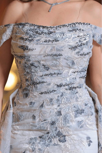 فستان سهرة فضّي مزدان بتطريزات زهرية راقية وتصميم...