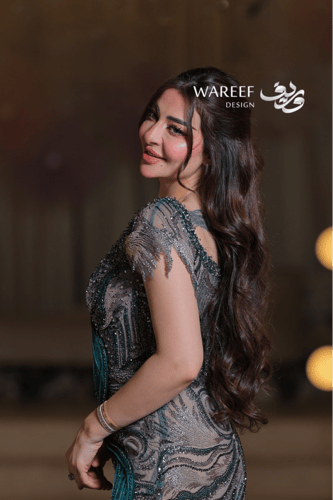 فستان سهرة بلون أخضر زمردي مطرّز بتفاصيل فاخرة وتص...