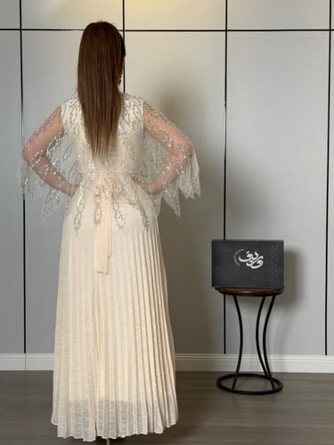 فستان ناعم عاجي فاخر بتطريز كريستالي وأكمام شيفون...