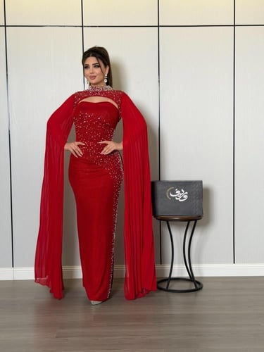 فستان سهرة أحمر ناري بتطريز كريستالي وأكمام كيب فا...