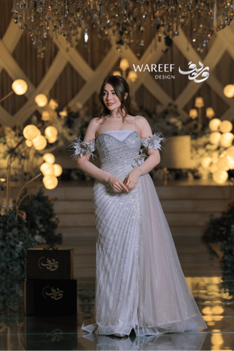 فستان سهرة فضي فاخر بتطريز لامع وأكمام من الريش ال...