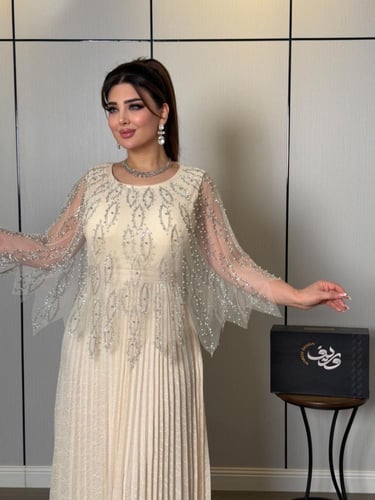 فستان ناعم عاجي فاخر بتطريز كريستالي وأكمام شيفون...