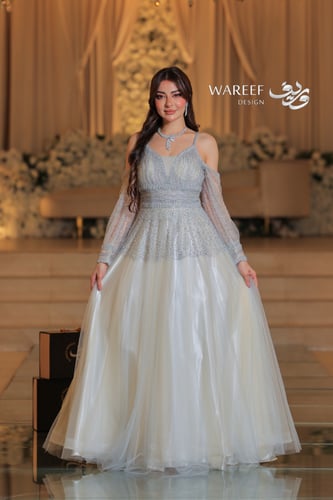 فستان سماوي فاتح مع فتحه بالكتف مزين بالفصوص اللام...