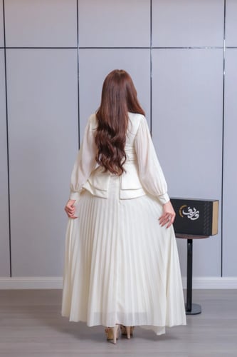 فستان ناعم باللون العاجي بتصميم أنيق وتنورة بليسيه...