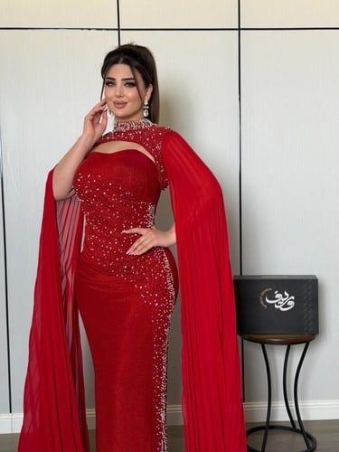 فستان سهرة أحمر ناري بتطريز كريستالي وأكمام كيب فا...