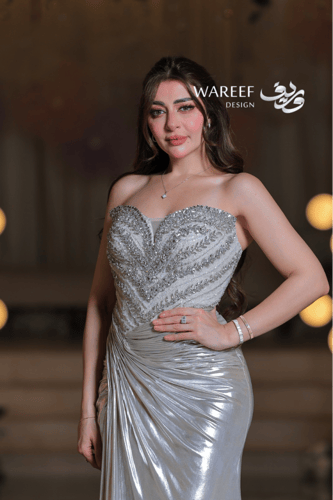 فستان سهرة فضي لامع بتطريز فاخر وقصّة ملتفّة لإطلا...