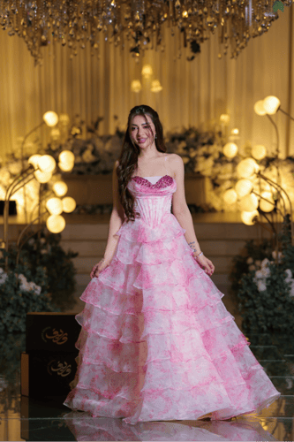 فستان سهرة وردي بطبقات تول متدرجة وتصميم كورسيه