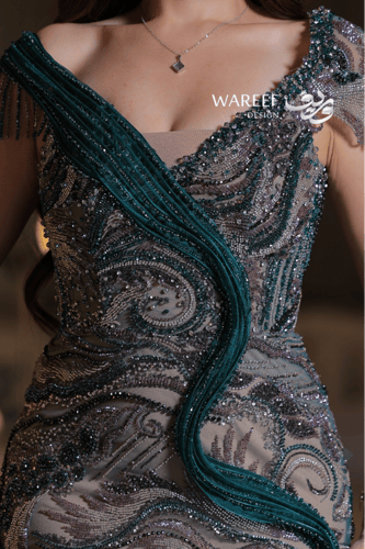 فستان سهرة بلون أخضر زمردي مطرّز بتفاصيل فاخرة وتص...