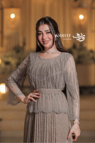 فستان سهرة بلون الشامبين بقصة طبقات وتنورة بليسيه