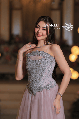 فستان سهرة وردي فاتح بتطريز فضّي كريستالي فاخر وقص...