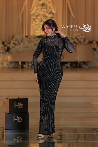 فستان أسود ضيق مزين بخطوط لامعة وأكمام شيفون شفافة