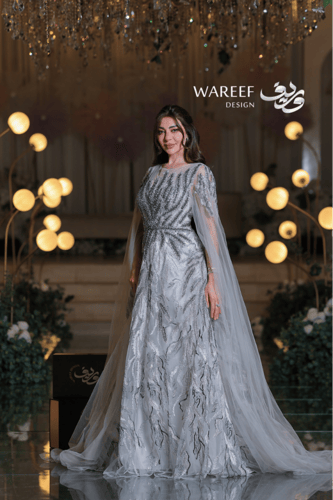 فستان سهرة فضي فخم بتطريز لامع وكاب شفّاف لإطلالة...