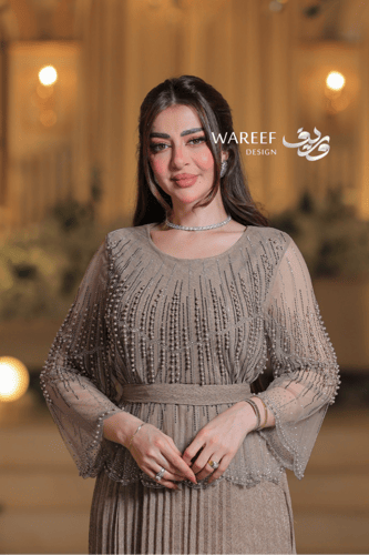 فستان سهرة بلون الشامبين بقصة طبقات وتنورة بليسيه