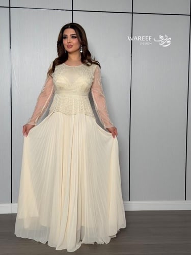 فستان أوف وايت بتطريز لؤلؤي وأكمام شفافة راقية