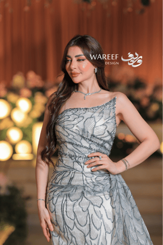 فستان سهرة عاجي فاخر بتطريز زهري لامع وقصّة كتف وا...