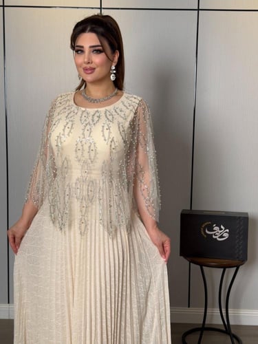 فستان ناعم عاجي فاخر بتطريز كريستالي وأكمام شيفون...