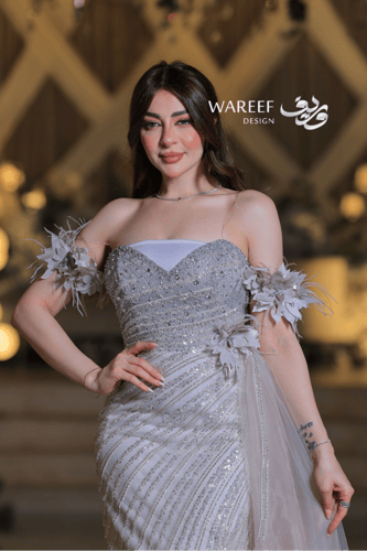 فستان سهرة فضي فاخر بتطريز لامع وأكمام من الريش ال...