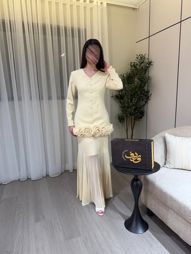 فستان كريمي أنيق بتفاصيل ورود بارزة وقصّة أنثوية ر...