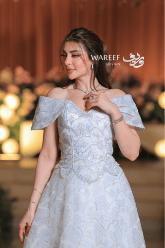 فستان سهرة ملكي فضّي بلمعة كريستالية وتصميم أكتاف...