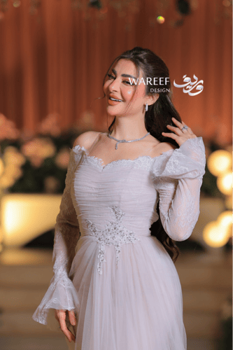 فستان عاجي ناعم بتصميم أكتاف منسدلة ودانتيل راقٍ ب...