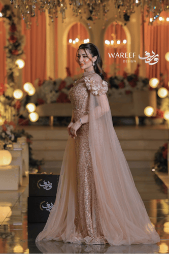 فستان سهرة فاخر بترتر ذهبي وأكمام شفافة مزينة بالو...