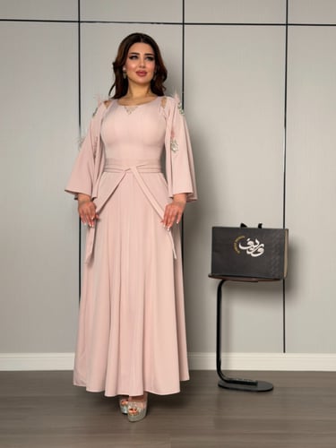فستان ناعم بلون وردي هادئ بأكمام واسعة وتفاصيل ريش...