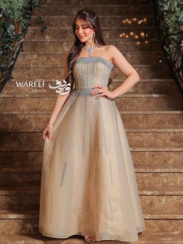فستان سهرة باللون البيج مزين بتطريز لامع وفخم