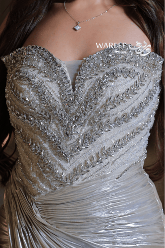 فستان سهرة فضي لامع بتطريز فاخر وقصّة ملتفّة لإطلا...