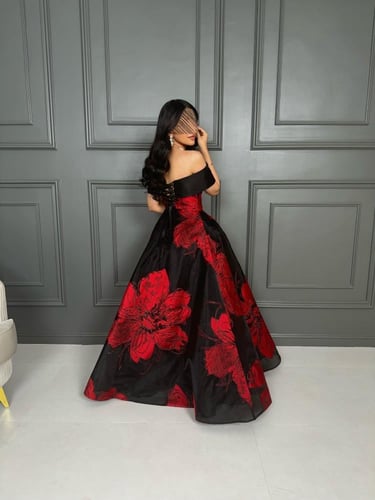 فستان سهرة أسود بأزهار حمراء كبيرة
