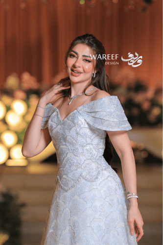 فستان سهرة ملكي فضّي بلمعة كريستالية وتصميم أكتاف...