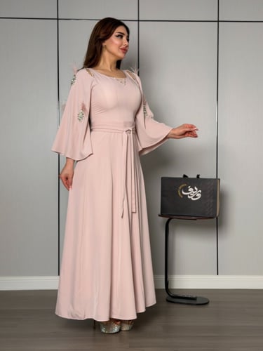 فستان ناعم بلون وردي هادئ بأكمام واسعة وتفاصيل ريش...