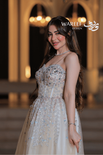 فستان بيج طويل بأحجار لامعة وتنورة واسعة