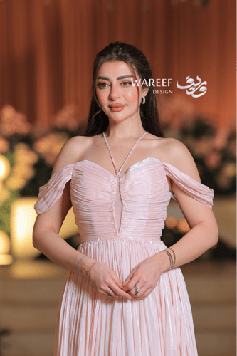 فستان سهرة وردي ناعم بتصميم ملكي وأكتاف منسدلة ولم...