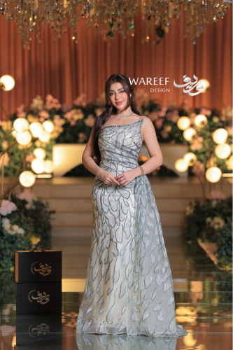 فستان سهرة عاجي فاخر بتطريز زهري لامع وقصّة كتف وا...