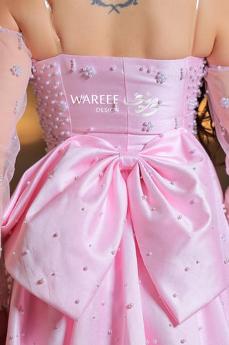 فستان وردي طويل مطرز بلمعة ناعمة مع أكمام شفافة وق...