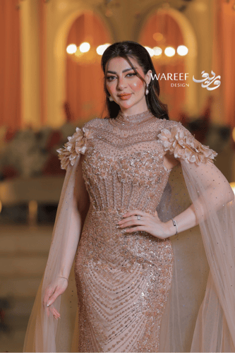 فستان سهرة فاخر بترتر ذهبي وأكمام شفافة مزينة بالو...