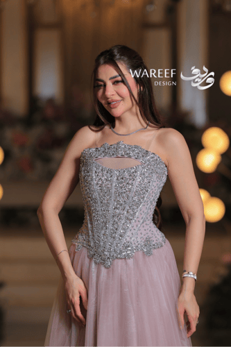 فستان سهرة وردي فاتح بتطريز فضّي كريستالي فاخر وقص...