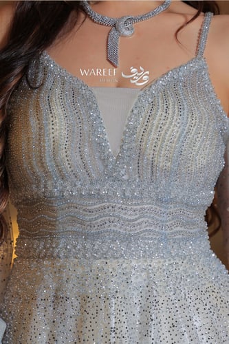 فستان سماوي فاتح مع فتحه بالكتف مزين بالفصوص اللام...