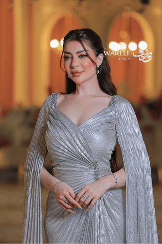 فستان سهرة فضي لامع بأكمام طويلة وتصميم درامي