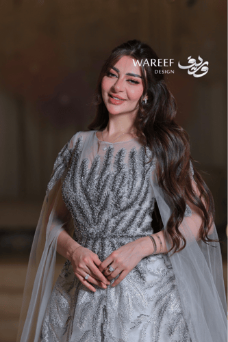 فستان سهرة فضي فخم بتطريز لامع وكاب شفّاف لإطلالة...