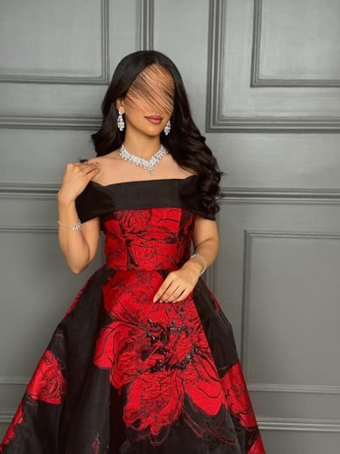 فستان سهرة أسود بأزهار حمراء كبيرة