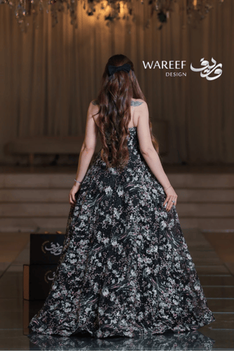 فستان أسود طويل مطرّز بالورود الملونة مع لمسات ترت...